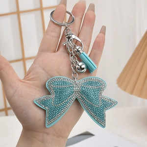 Close-up of light blue rhinestone bow keychain with matching tassel and silver bell