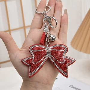 Sparkling red rhinestone bow keychain with leather tassel and silver hardware details