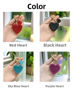 Detailed view of four rhinestone heart keychains in red, black, blue, and purple colors