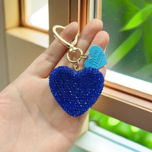 Close-up of heart keychain with blue rhinestones and gold-tone lobster clasp detail