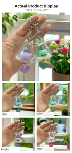 Detail of four colorful acrylic bell keychains with cute cartoon cats and heart pendants