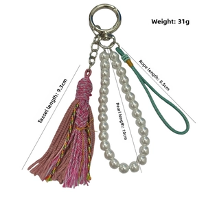 Detail showing dimensions of pink tassel, faux pearl chain, and green cord bag charm