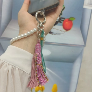Handmade pearl wrist strap with colorful tassel charm on a phone for elegant accessory style