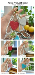 Detailed view of heart rhinestone keychains with pearl straps in four vibrant colors
