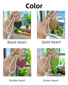 Detail view of heart-shaped diamond keychains in black, gold, rose, and green colors