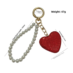 Detailed view of red rhinestone heart keychain with white pearl chain and 10cm strap