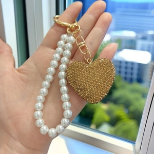 Elegant pearl bead chain with a gold heart pendant and sparkling rhinestone details