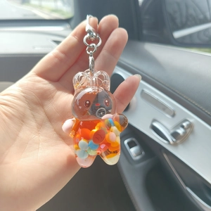 Close-up of crown bear acrylic keychain filled with colorful sequins and liquid sand