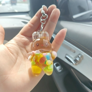 Detail of creative bear shaped acrylic keychain with colorful beads held in hand