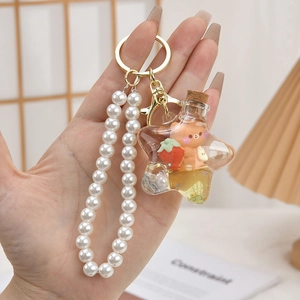 Close-up of star shaped fluid bottle keychain with bear and pearl bead handle