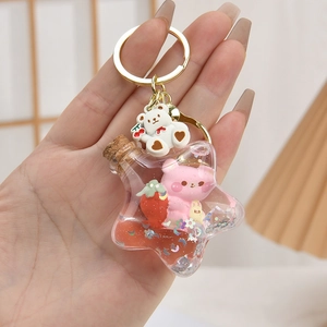 Detail of pink bear and red strawberry inside a star-shaped liquid drifting bottle