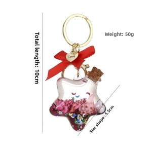 Detail eines sternförmigen Treibflaschen Schlüsselanhängers mit rosa Muscheln und Anhänger