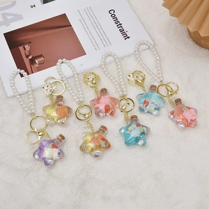 Star-shaped liquid charm keychains with cute bears and pearl wristbands in multiple colors