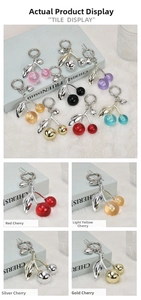 Detailed view of various cherry charms with metallic leaves and colorful resin beads