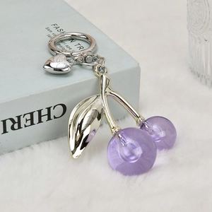 Detail of purple cherry keychain with silver leaves and small heart pendant