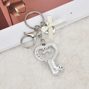 Silver heart key pendant with crystals, white ribbon bow, and small metal heart tag