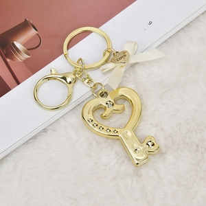 Golden heart key keychain with rhinestone crown, cream bow and Love heart charm on white fur