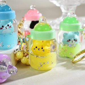 Detail of cat shaped milk bottle keychains with colorful liquid and star sequins