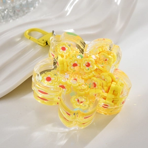 Close-up of flower-shaped acrylic keychain with yellow sequins and a metal clasp