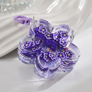 Macro detail of acrylic petal keychain with purple flower slices and glitters