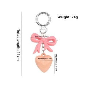 Pink bow and heart keychain detail with size dimensions in centimeters and grams