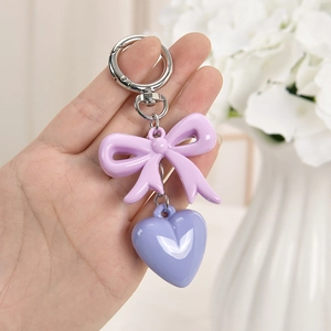 Close-up of a sweet purple bow and heart pendant charm for bags and keys