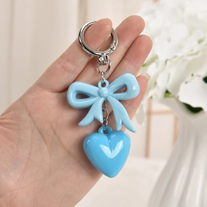Detailed shot of sky blue bow and heart keychain charm with polished silver ring