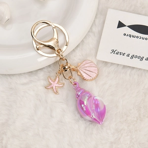 Ocean theme keychain with purple conch pink starfish and shell charm on light gold hook
