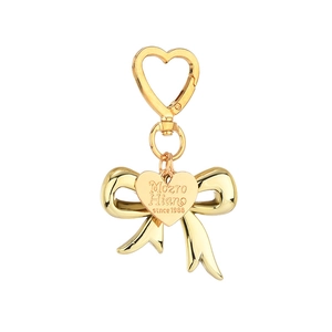 Golden heart-shaped keychain with bow pendant and polished metallic finish on white background