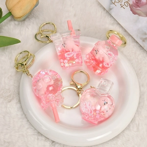 Pink liquid acrylic keychain set with capybara and rabbit figures in glitter bottles