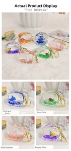 Macro detail of acrylic liquid sand keychain featuring a floating cartoon clownfish charm