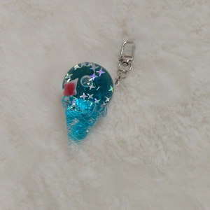 Close-up of a blue gradient ice cream keychain made of resin with a metal lobster clasp