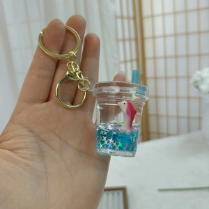 Ocean floating bottle acrylic keychain with dolphin and star sequins in liquid blue charm