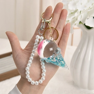 Detailed shot of ice cream acrylic keychain with pearl strap and blue textured cone