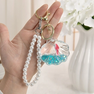 Blue seashell liquid keychain with floating glitter, pink fish, and pearl bead chain