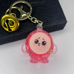 Detailed view of Chiikawa-style pink resin keychain with liquid glitter and golden bell