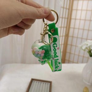 Details eines grünen Lutscher-Schlüsselanhängers mit Good Luck auf der Handschlaufe