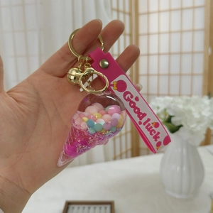Nahaufnahme vom Eisbären-Flüssig-Schlüsselanhänger mit rosa Band und goldener Glocke