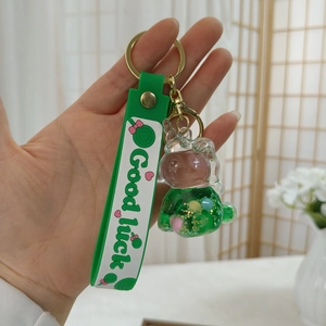 Detail eines grünen Hasen-Schlüsselanhängers mit Good Luck-Band und goldener Schließe