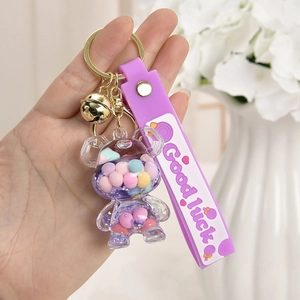 Detailaufnahme des violetten Bären-Schlüsselanhängers mit Good Luck-Handschlaufe und Glocke