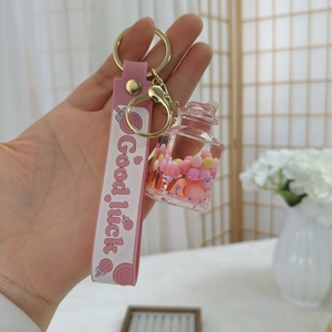 Detailansicht vom rosa Schlüsselanhänger mit Good Luck Band und flüssiger Füllung