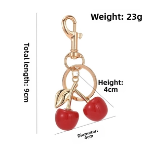 Detail view of a cherry keychain with dimensions, showing size and weight specs