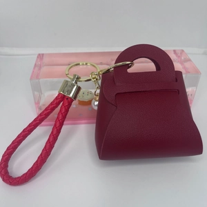 Detailansicht Mini-Taschenanhänger aus weinrotem Kunstleder mit Perle und Goldring