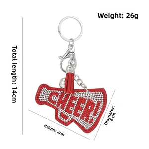 Detail of red and white rhinestone megaphone keychain with tassel and silver bell