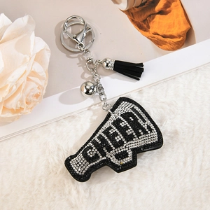 Macro detail of rhinestone encrusted CHEER megaphone keychain with tassel and bell