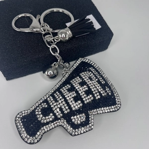 Macro detail of cheer rhinestone megaphone keychain with black tassels and silver ring