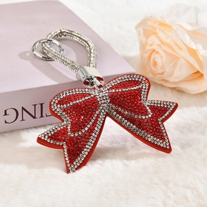 Detailed view of red rhinestone bow keychain with velvet finish and crystal hand strap
