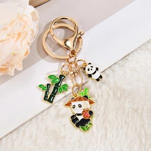 Detaillierte Nahaufnahme eines goldenen Panda-Schlüsselanhängers mit Bambus und Sake-Krug-Anhängern