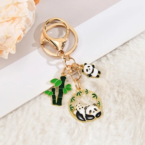 Detailansicht eines Panda-Schlüsselanhängers mit goldenen Metallanhängern und grünem Bambus