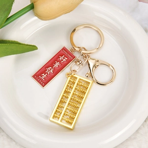 Golden metal abacus keychain with red tag and Good Things Happen blessing message